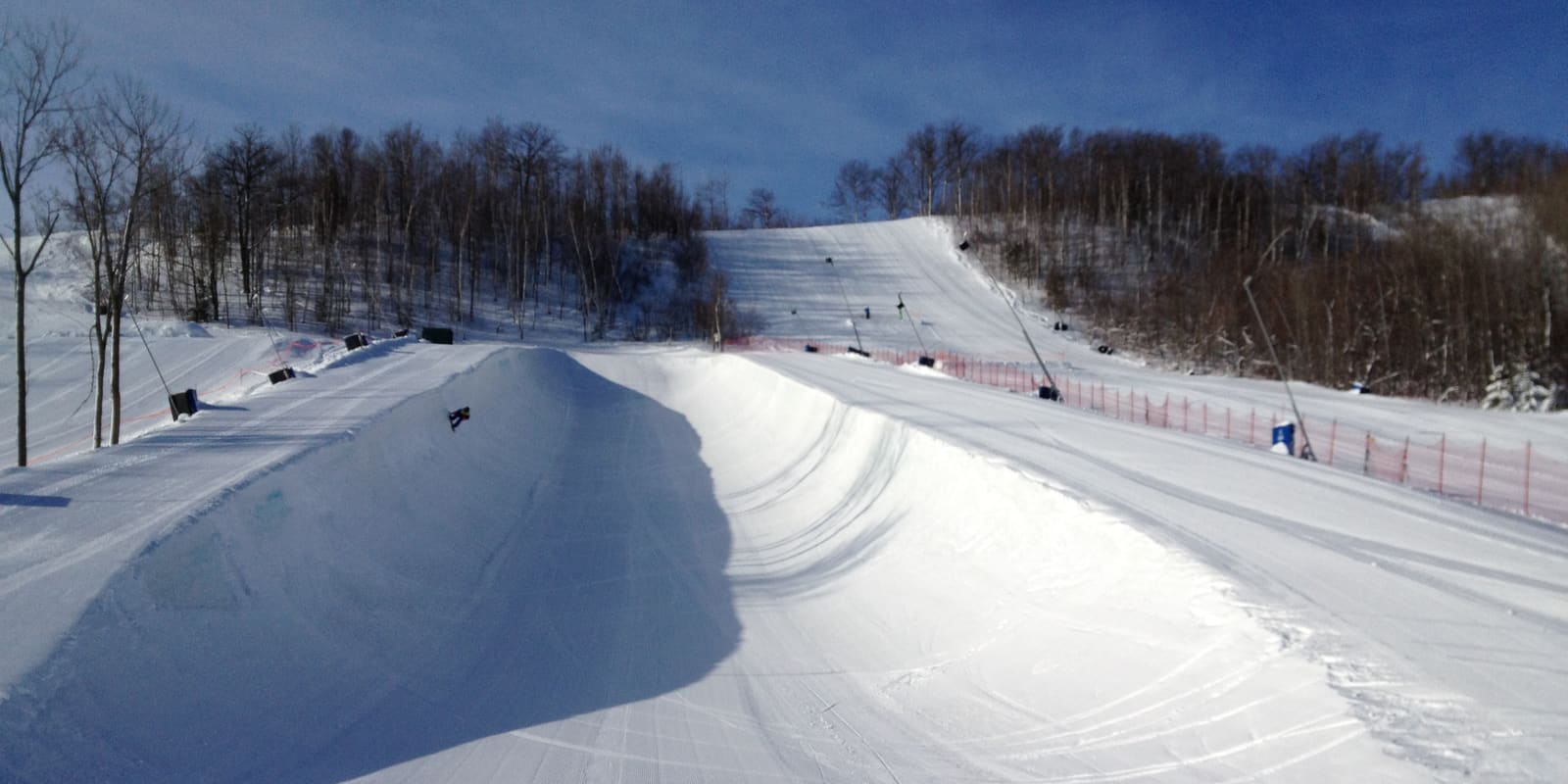 A freshly groomed snowboard halfpipe on a sunny winter day