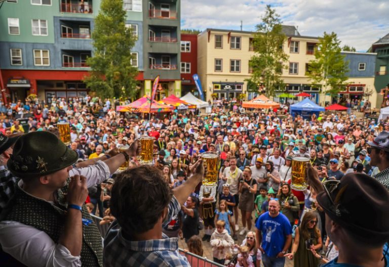 Crowd raising steins at Keystone Oktoberfest in River Run Village